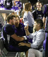 Jeff Redenius testing for concussion on a football player on the sideline